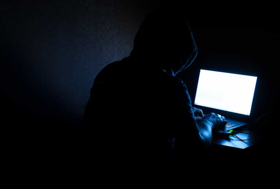 Mysterious Figure in a Dark Room with a Bright Computer